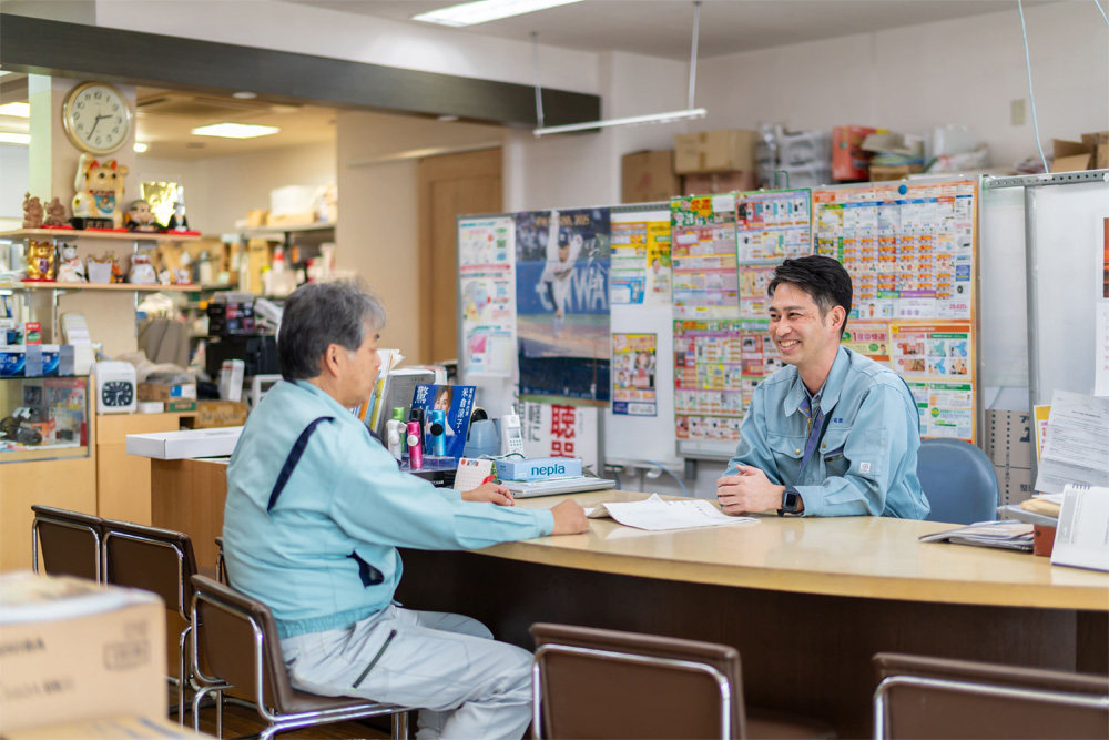 作業服を着た3人のビジネスパーソンが笑顔で並んでいる